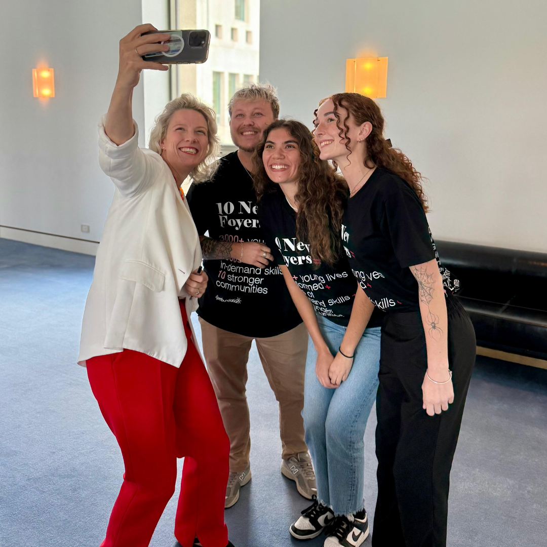 Federal Minister for Housing and Homelessness Clare O'Neil holds a camera phone to take a selfie with Ambassadors Ash, Tyrah and Caitlyn at Parliament House.